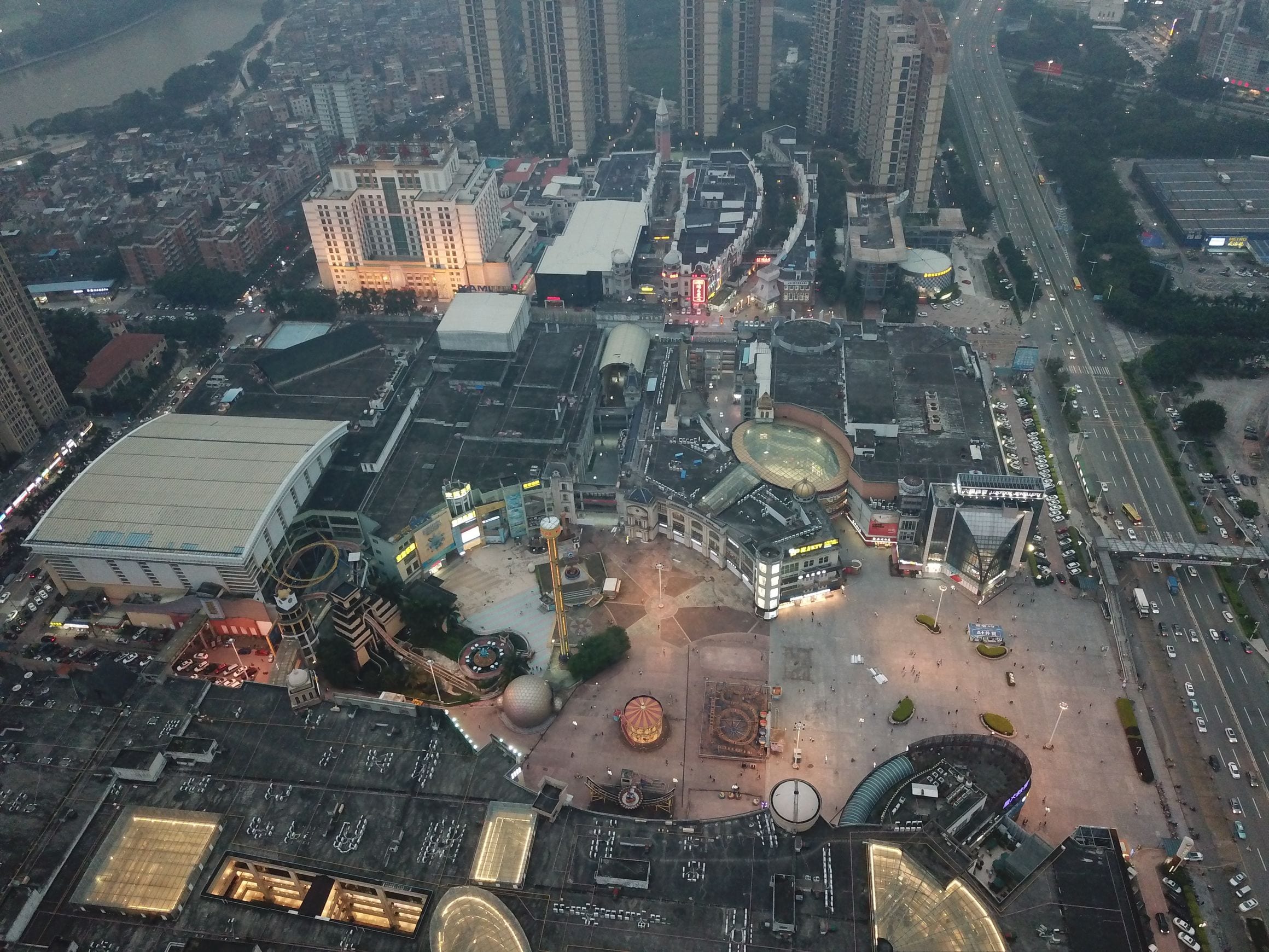 An aerial dusk view over the plazas, arena roof and themed buildings of the South China Mall in Wanjiang District, Dongguan