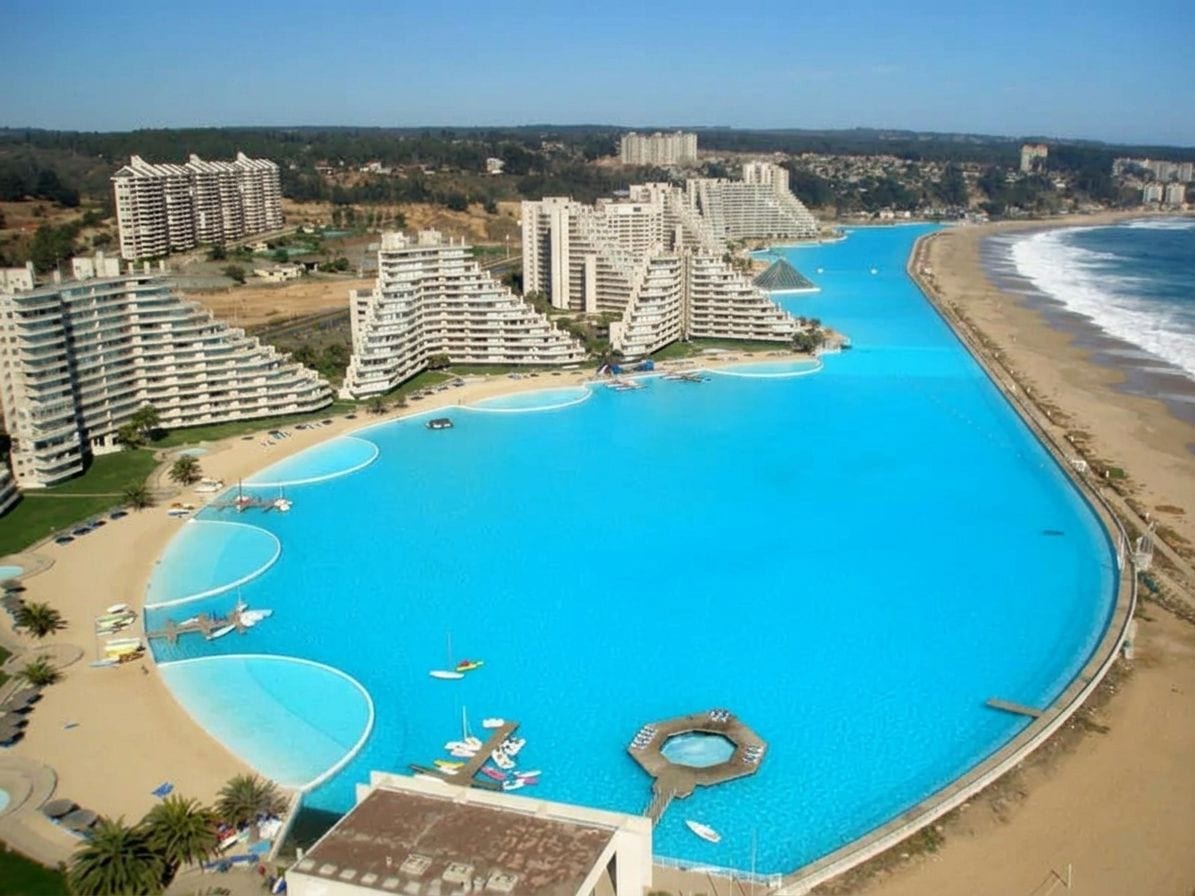 Aerial view of a vast turquoise man-made swimming lagoon
