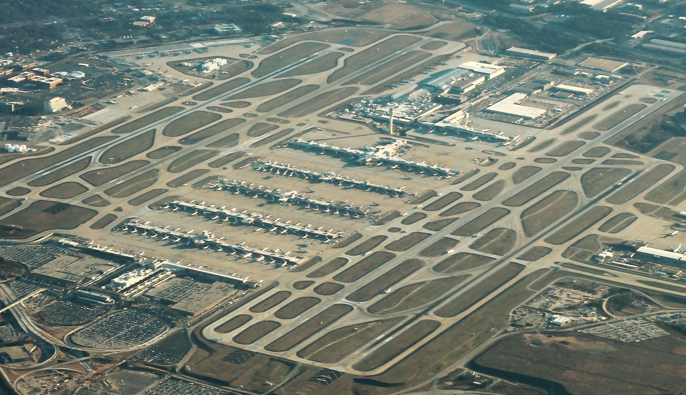 Aerial view of Hartsfield-Jackson Atlanta International Airport, its parallel concourses lined with jets between the runways