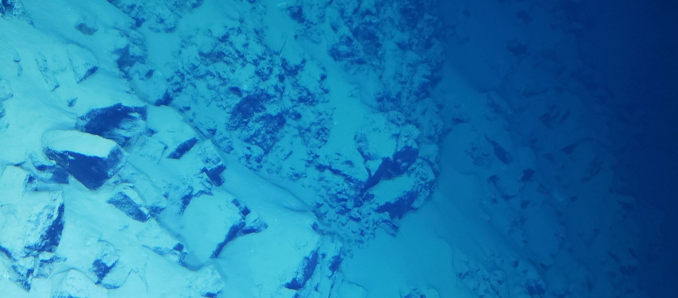 Boulders strewn down the southern wall of Challenger Deep in the Mariana Trench, photographed from the submersible Limiting Factor about 10,800 meters down
