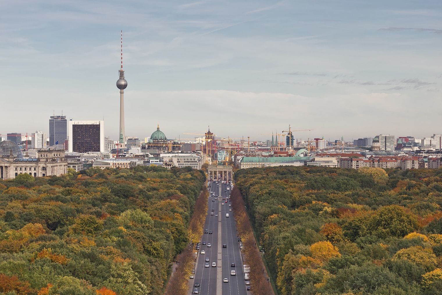 The view east from the Victory Column across the autumn Tiergarten to the Brandenburg Gate, with the Fernsehturm and Berlin Cathedral beyond