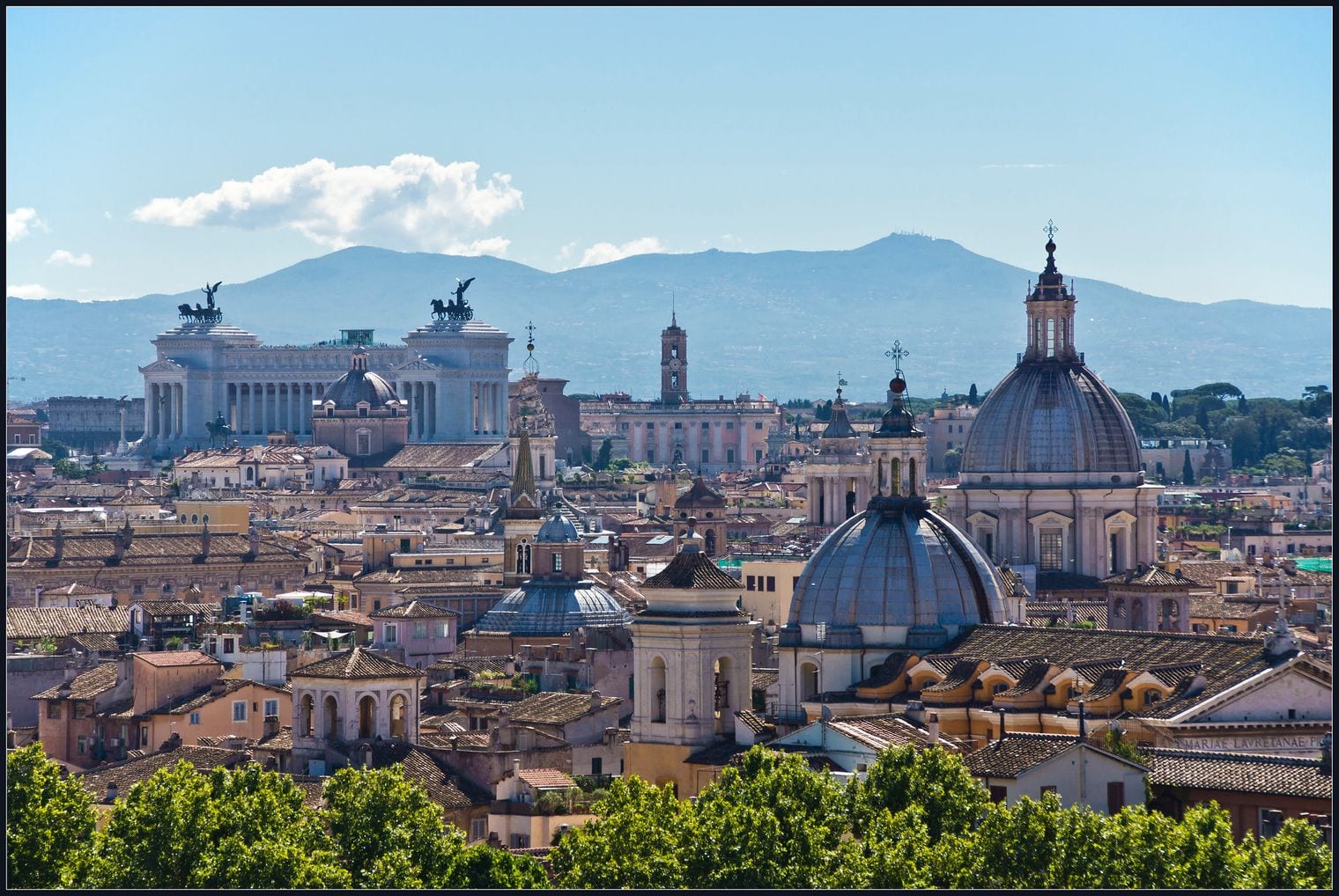 Rome rooftops and church domes across the historic centre, with hills on the horizon