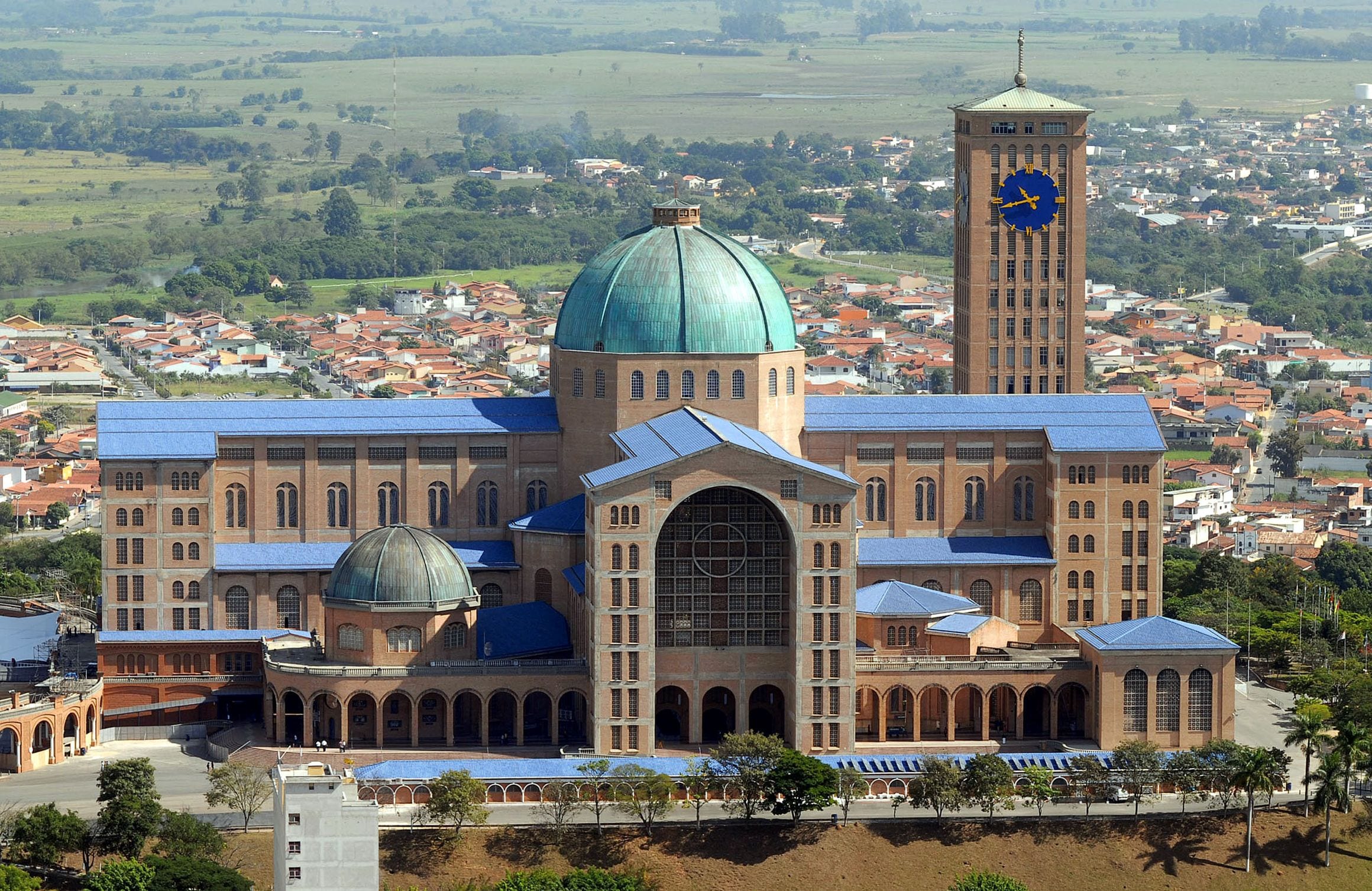 The green dome, brick nave and clock tower of the Basilica of Our Lady Aparecida rising over Aparecida, São Paulo, Brazil