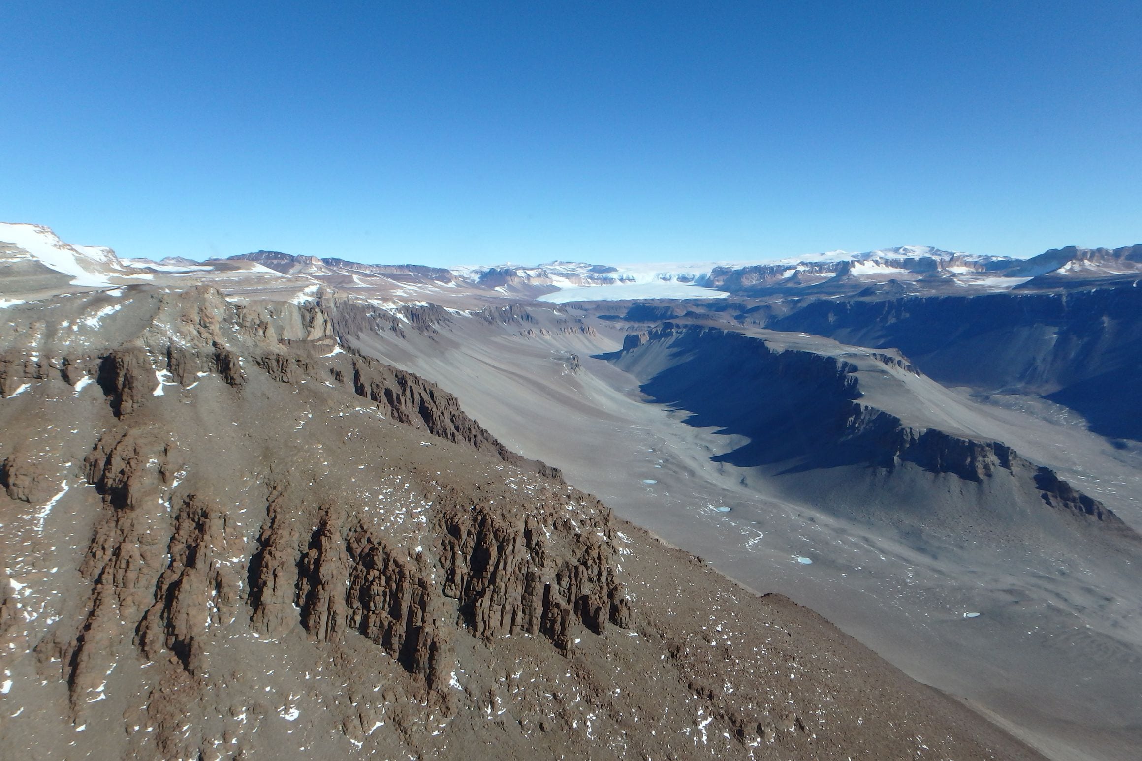 The bare, snow-free floor of Wright Valley in Antarctica's McMurdo Dry Valleys, with the ice of the polar plateau spilling in beyond