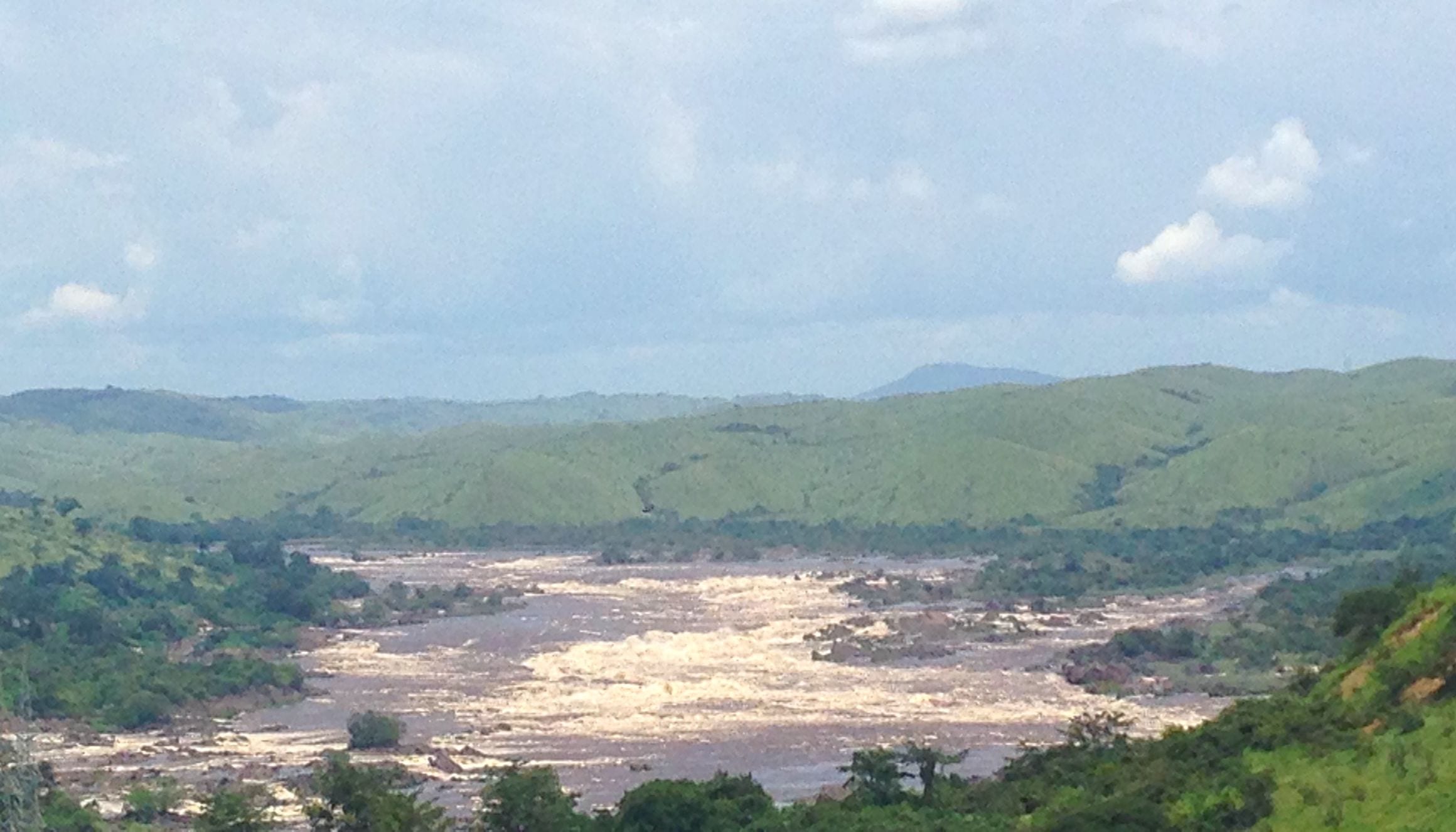 White-water cascades of Inga Falls spreading across the lower Congo River between green hills in Kongo Central, Democratic Republic of the Congo