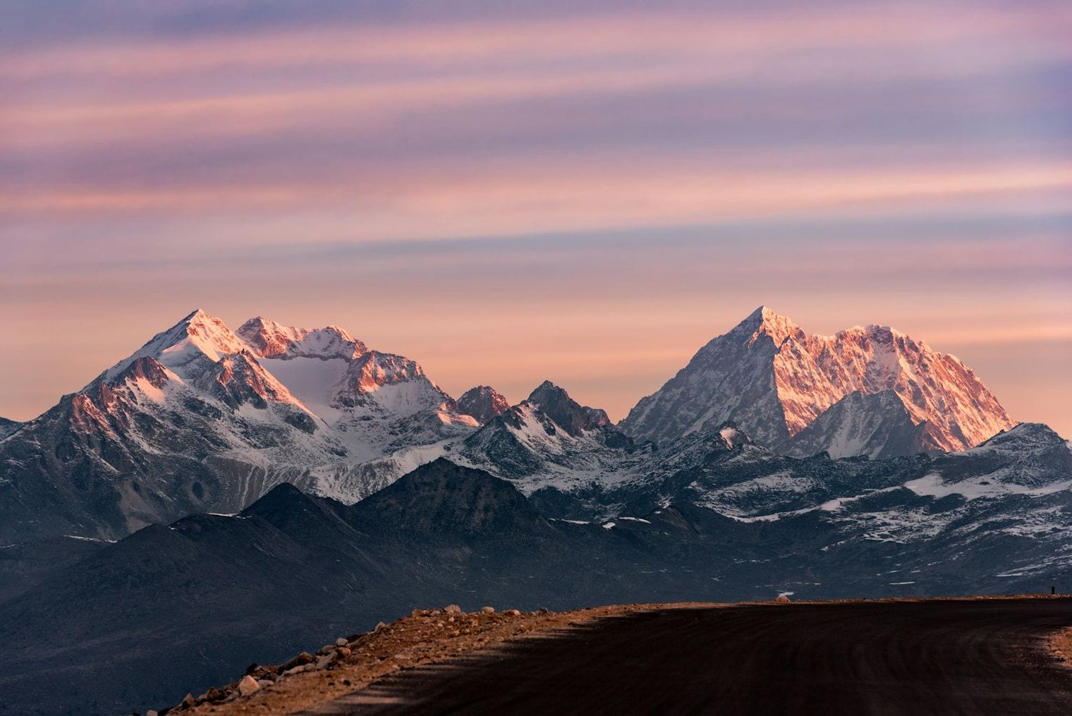 Layered mountain ridgelines receding into golden haze at sunset