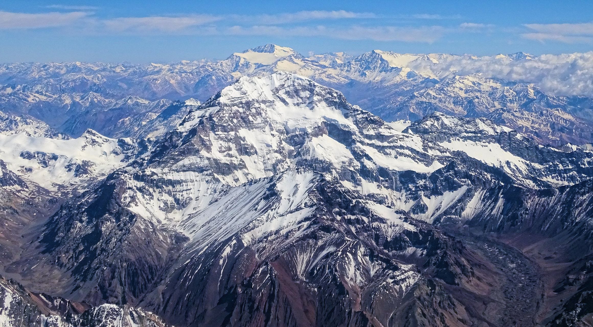 Snow-streaked Aconcagua towering over endless ridges of the Andes, with Mercedario on the horizon, seen from the air in Argentina