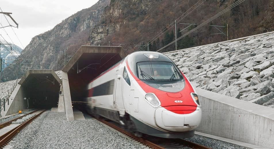 A red and white Swiss high-speed train emerging from the south portal of the Gotthard Base Tunnel, with a steep forested mountainside behind