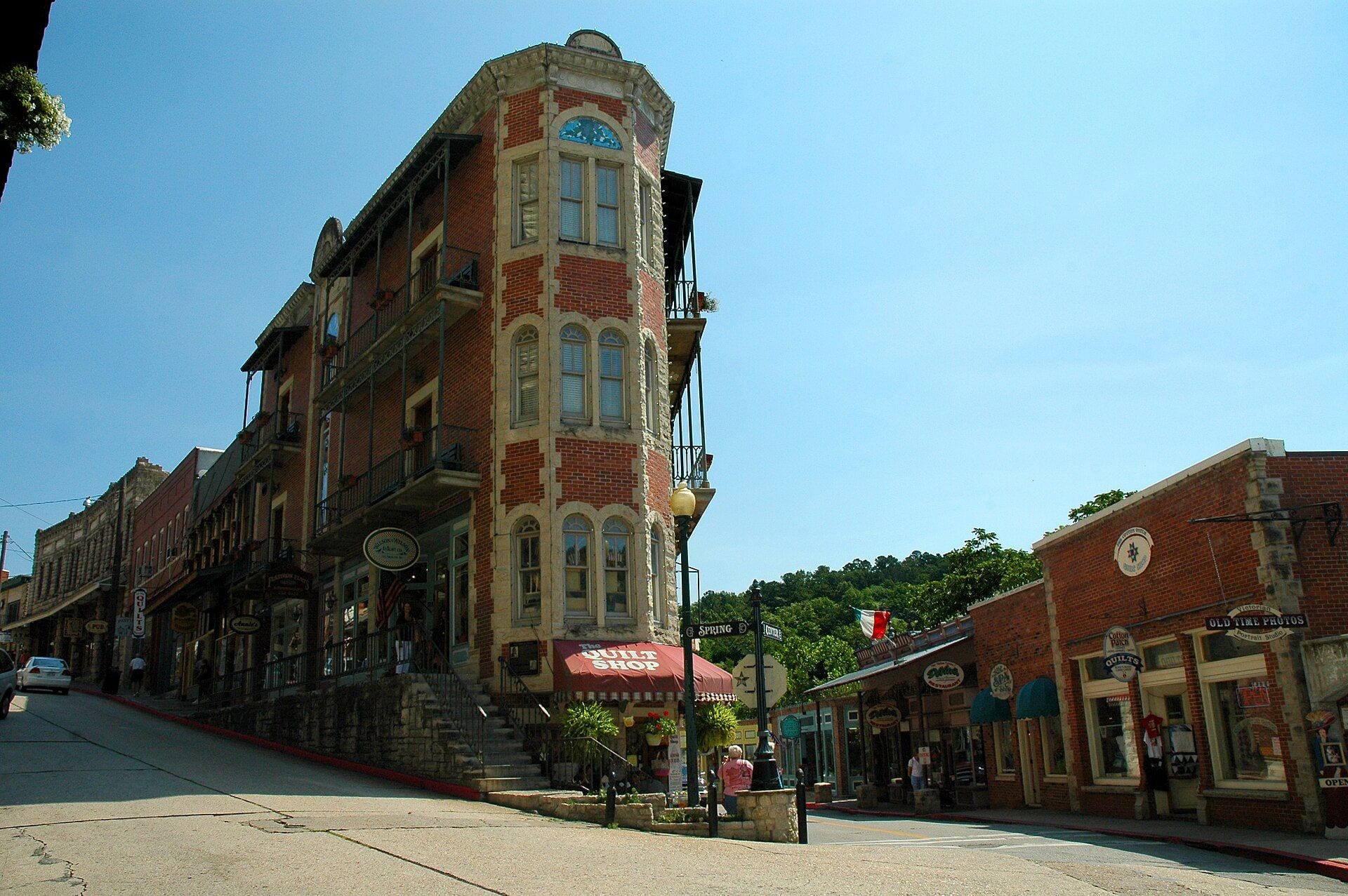 Spring Street in downtown Eureka Springs, Arkansas, with historic brick storefronts climbing the Ozark hillside