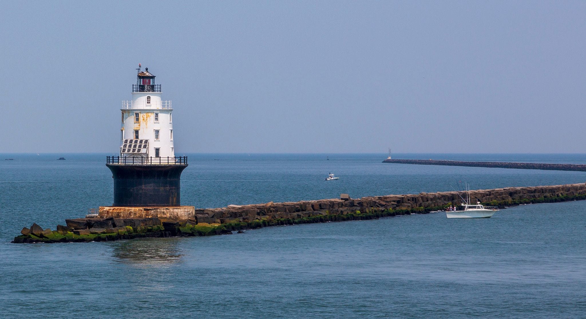 Harbor of Refuge Lighthouse on its stone breakwater off Lewes, Delaware, on calm Delaware Bay water