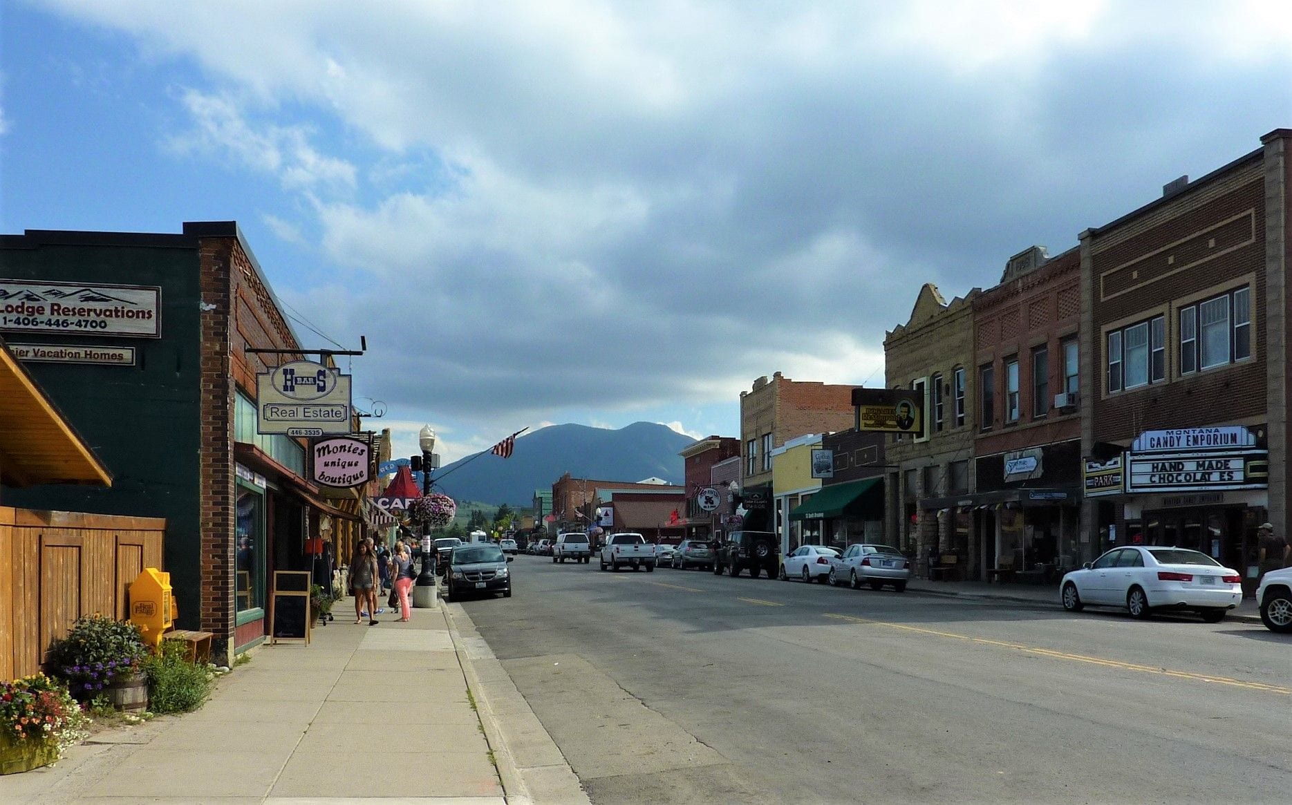 Main Street in Red Lodge, Montana, lined with historic brick storefronts beneath the Beartooth foothills