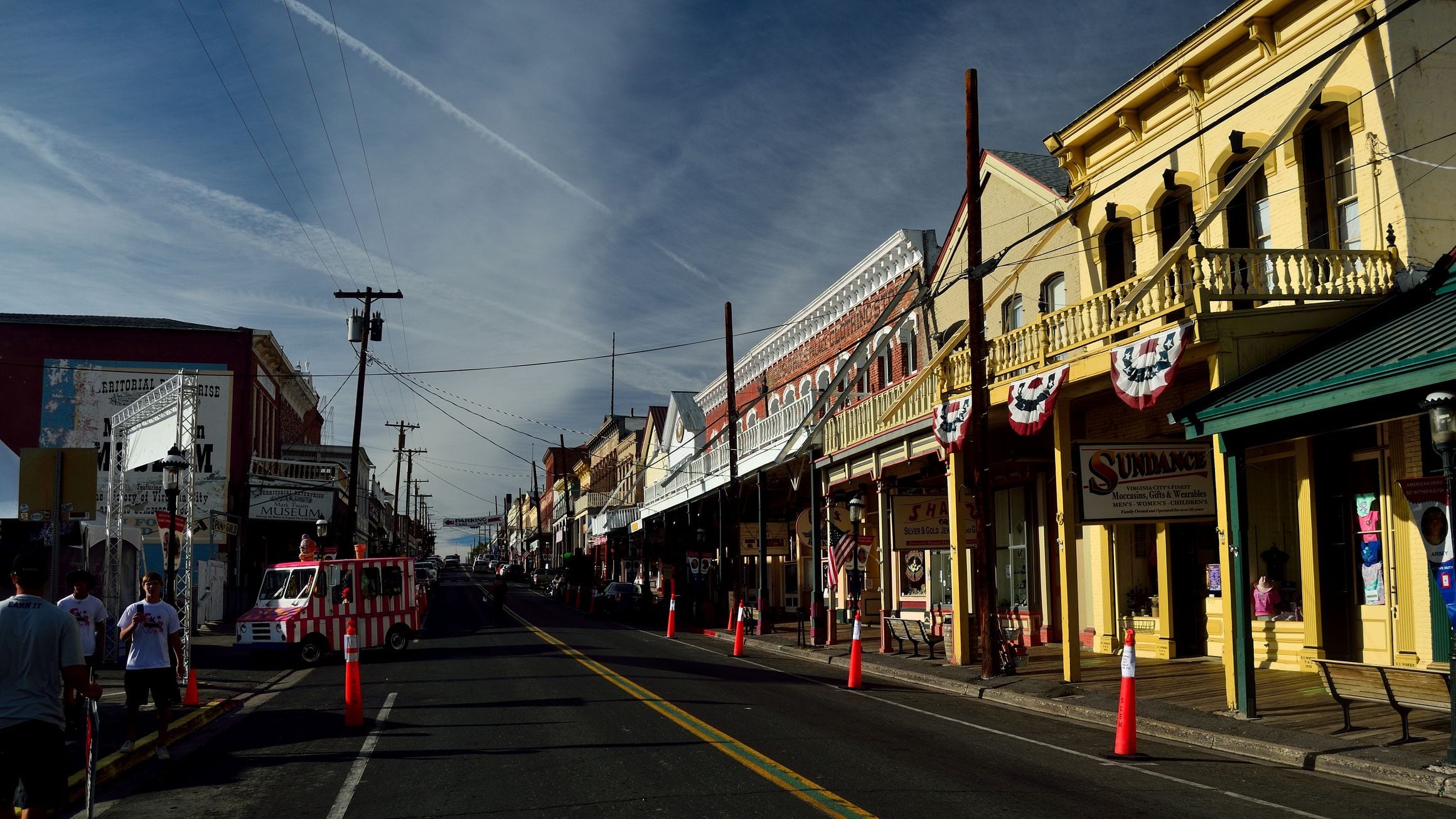 C Street in Virginia City, Nevada, lined with balconied Victorian-era brick and wood storefronts under a wide sky