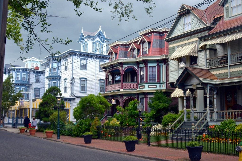 Brightly painted Victorian houses along a brick-sidewalk street in the Cape May historic district, New Jersey
