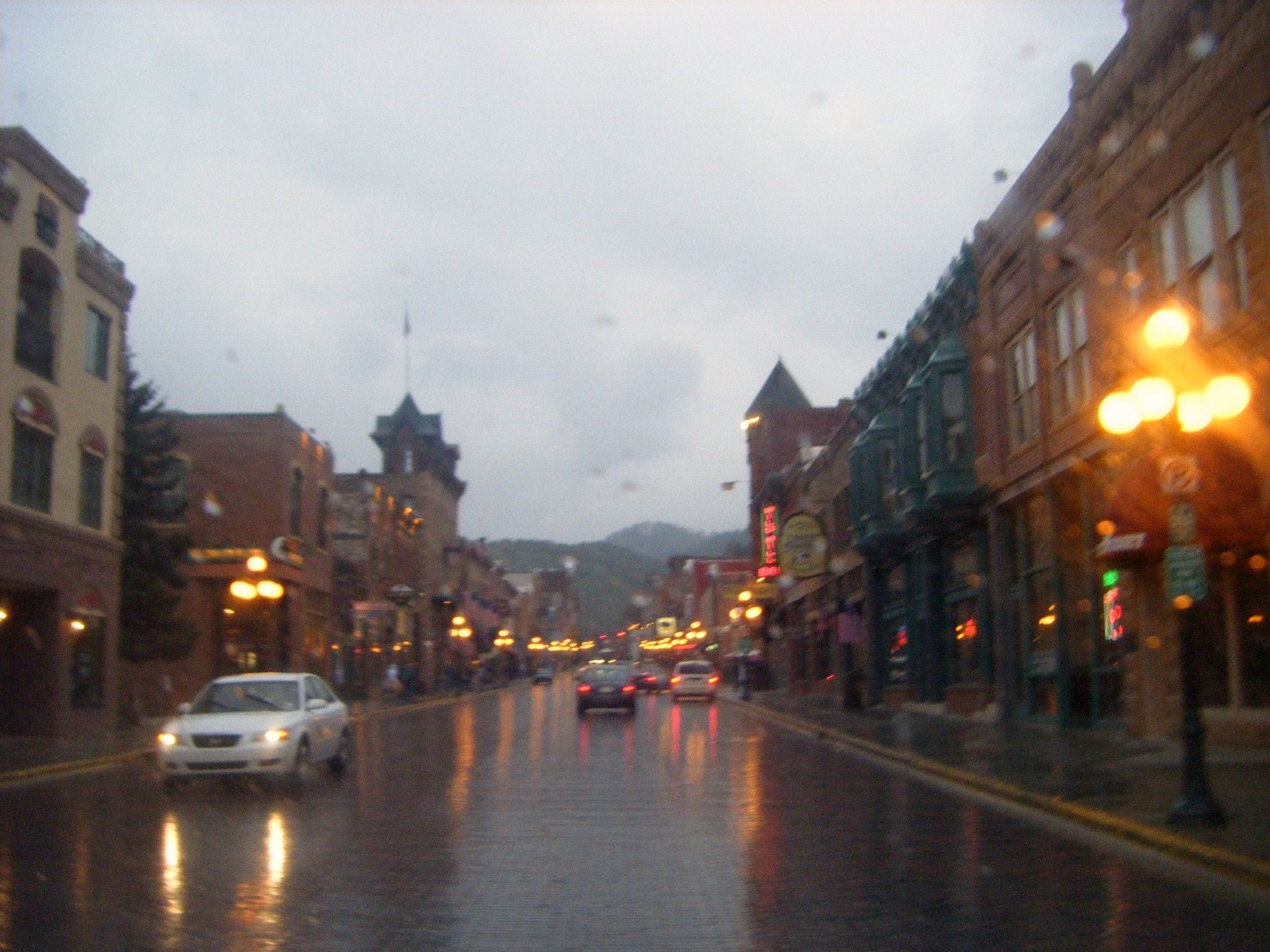 Historic brick buildings and street lamps along Main Street in Deadwood, South Dakota, in the Black Hills at dusk