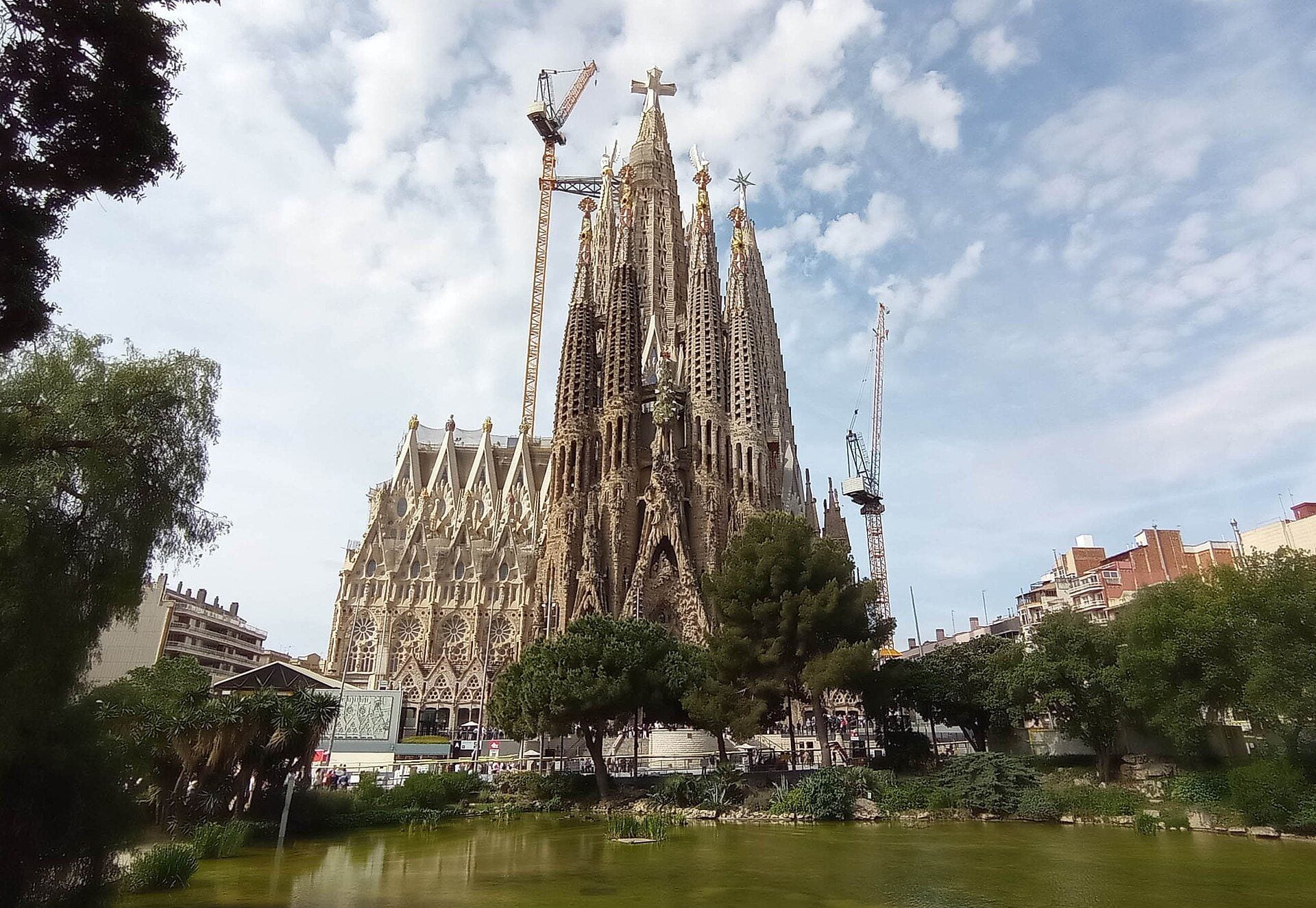 The Sagrada Família in Barcelona in 2026, its sculpted spires and construction cranes rising above the surrounding trees