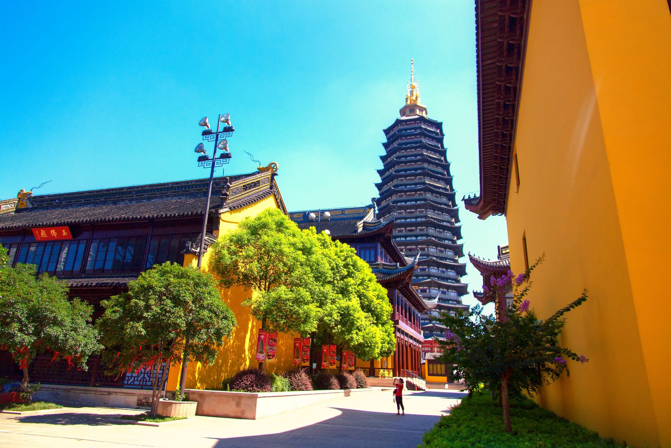 The gilded spire and dark tiered eaves of Tianning Pagoda rising above the yellow-walled halls of Tianning Temple in Changzhou, China