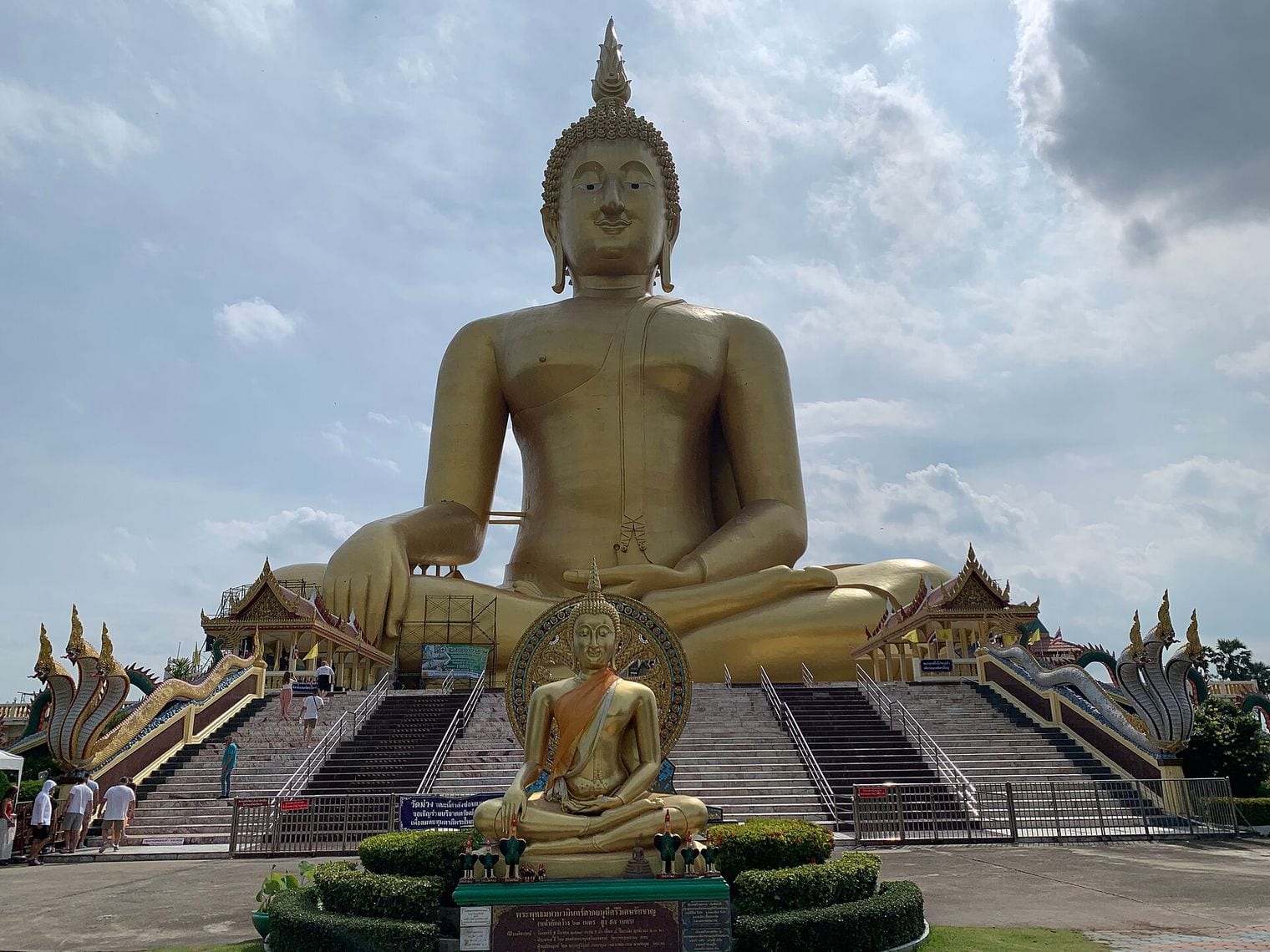 The gilded Great Buddha of Thailand seated above the naga-lined stairways at Wat Muang in Ang Thong province