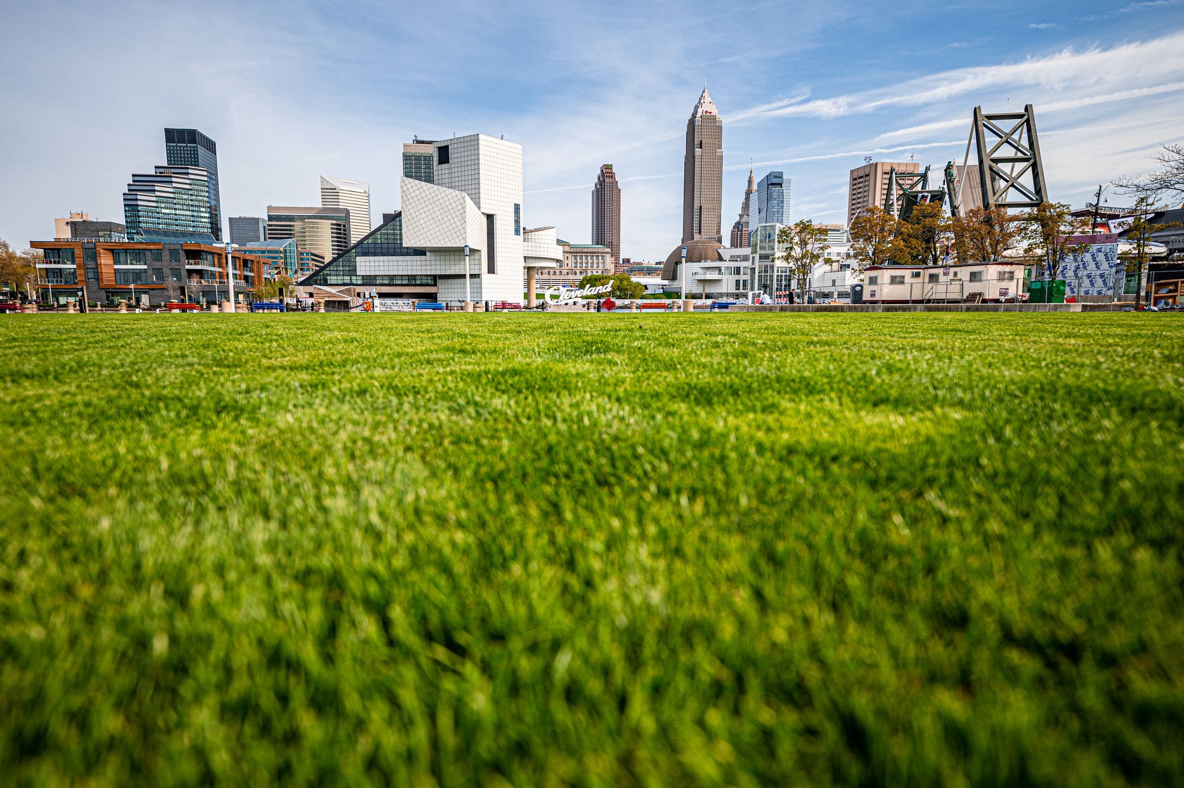 The Rock & Roll Hall of Fame beside the downtown Cleveland skyline, seen across the lawn at North Coast Harbor on Lake Erie