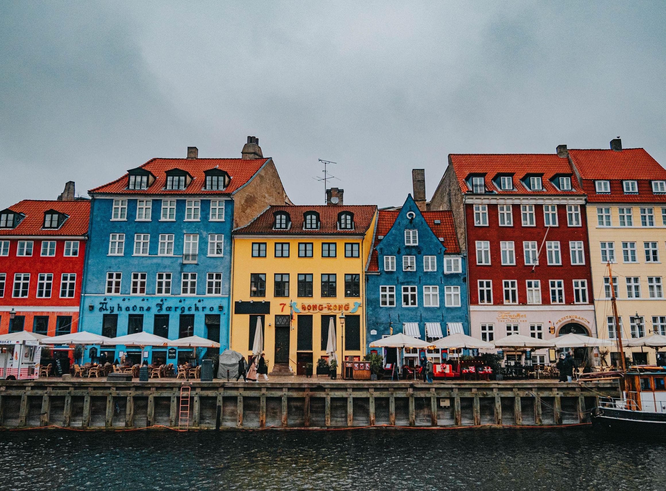 Colourful gabled townhouses and a moored wooden sailing ship along the Nyhavn canal quay in Copenhagen
