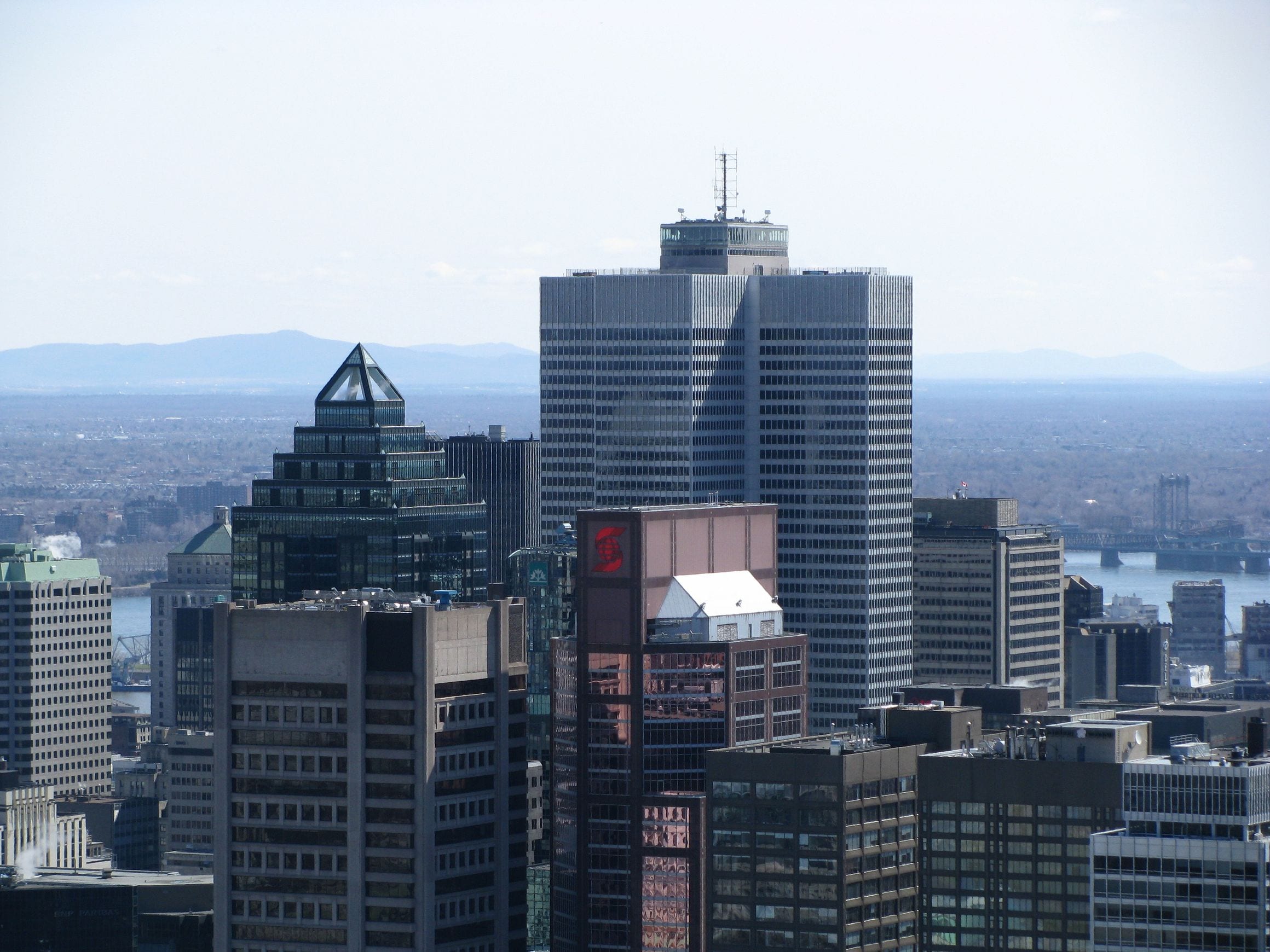 Montreal skyline seen from Mount Royal, with downtown towers, the St Lawrence River and its bridges beyond